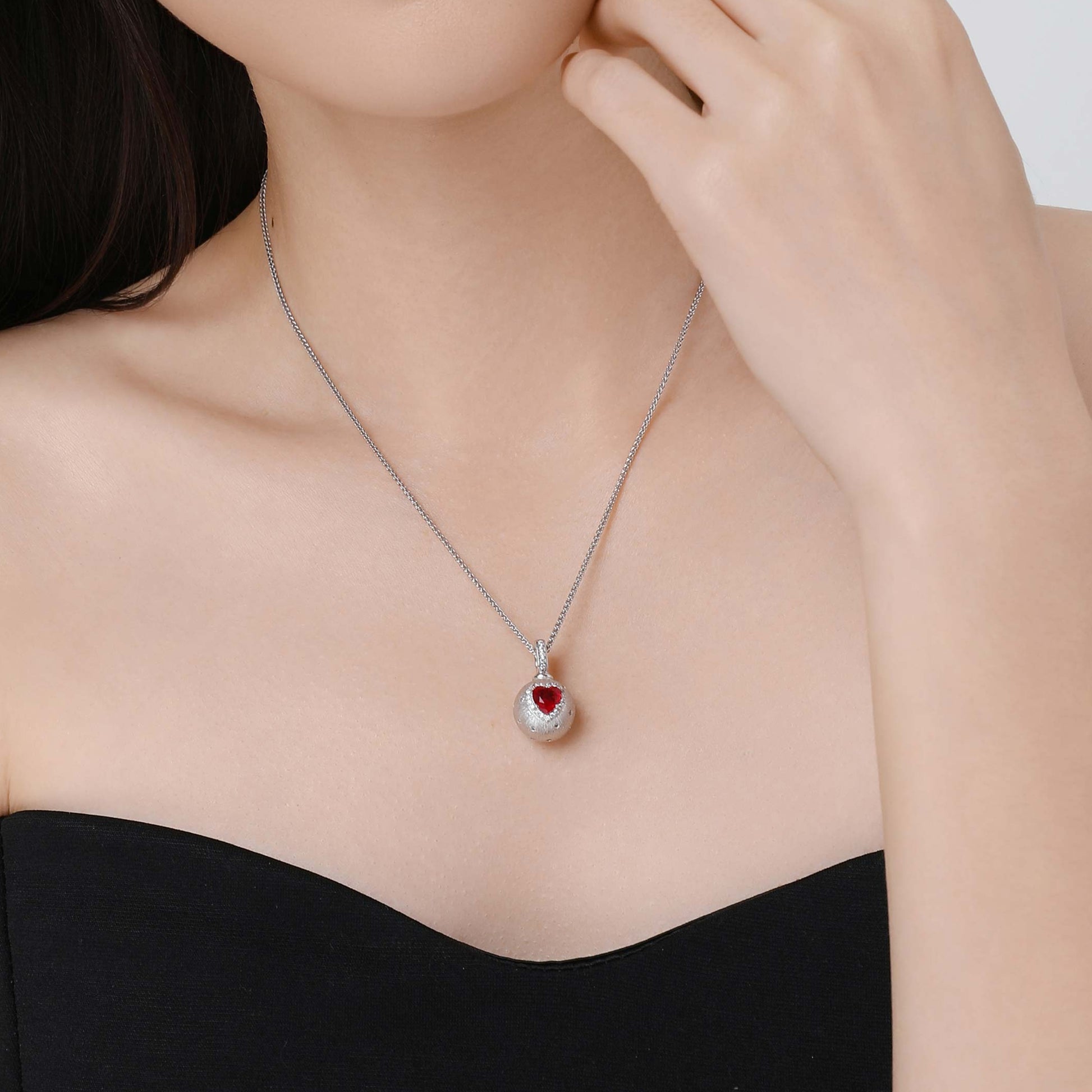 Model wearing the D-POW Cosmic Amour peach motif pendant, showcasing its elegant design as a statement piece of jewelry on the neck.