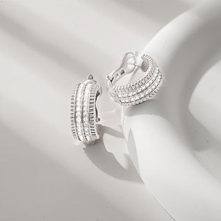 Close-up of the classic hoop earrings with baroque-style detailing, emphasizing the texture and shimmering stones.