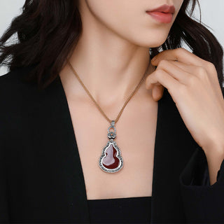 Styled shot of the cinnabar gourd pendant on model, paired with a minimalist outfit.