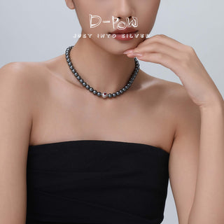 The D-POW Cosmic Amour peach motif necklace worn by a model, featuring the necklace’s luxurious and timeless design against a clean background.