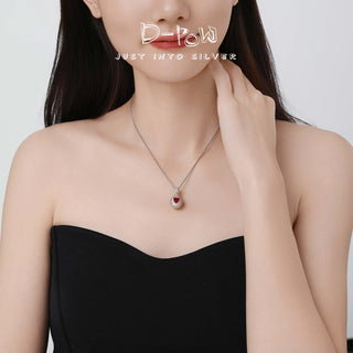 Side view of the D-POW Cosmic Amour peach motif pendant worn on the neck, highlighting its sleek, modern look and premium quality.