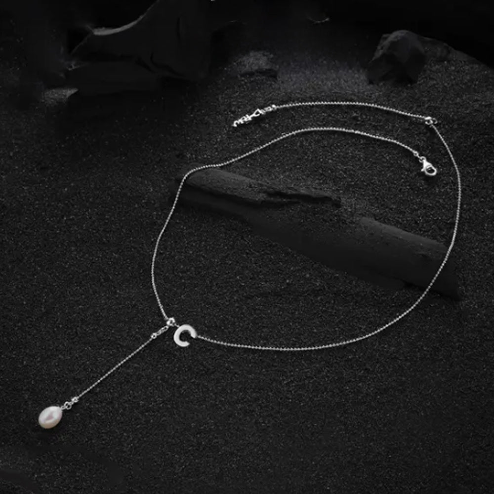 The "C" letter pendant from the cream-colored letter necklace, displayed with attention to detail and elegance.