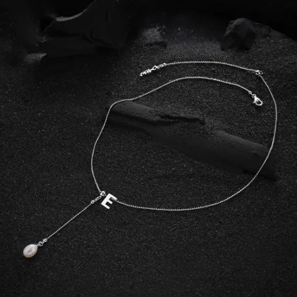 Cream-colored letter "E" pendant in a clean and sleek design, emphasizing the simplicity and beauty of the necklace.