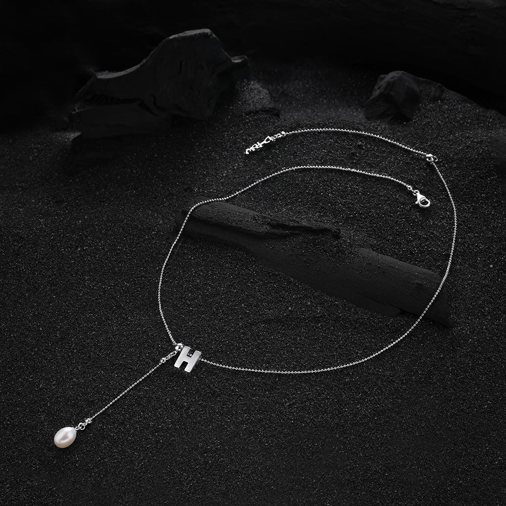 Letter "H" pendant from the cream-colored letter necklace, showing the refined design and detailed craftsmanship.