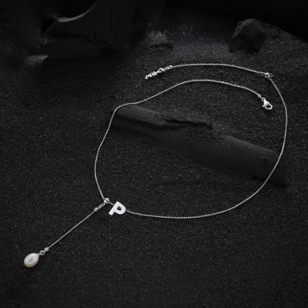 Letter "P" pendant from the cream-colored necklace, showcasing its elegant and timeless design.