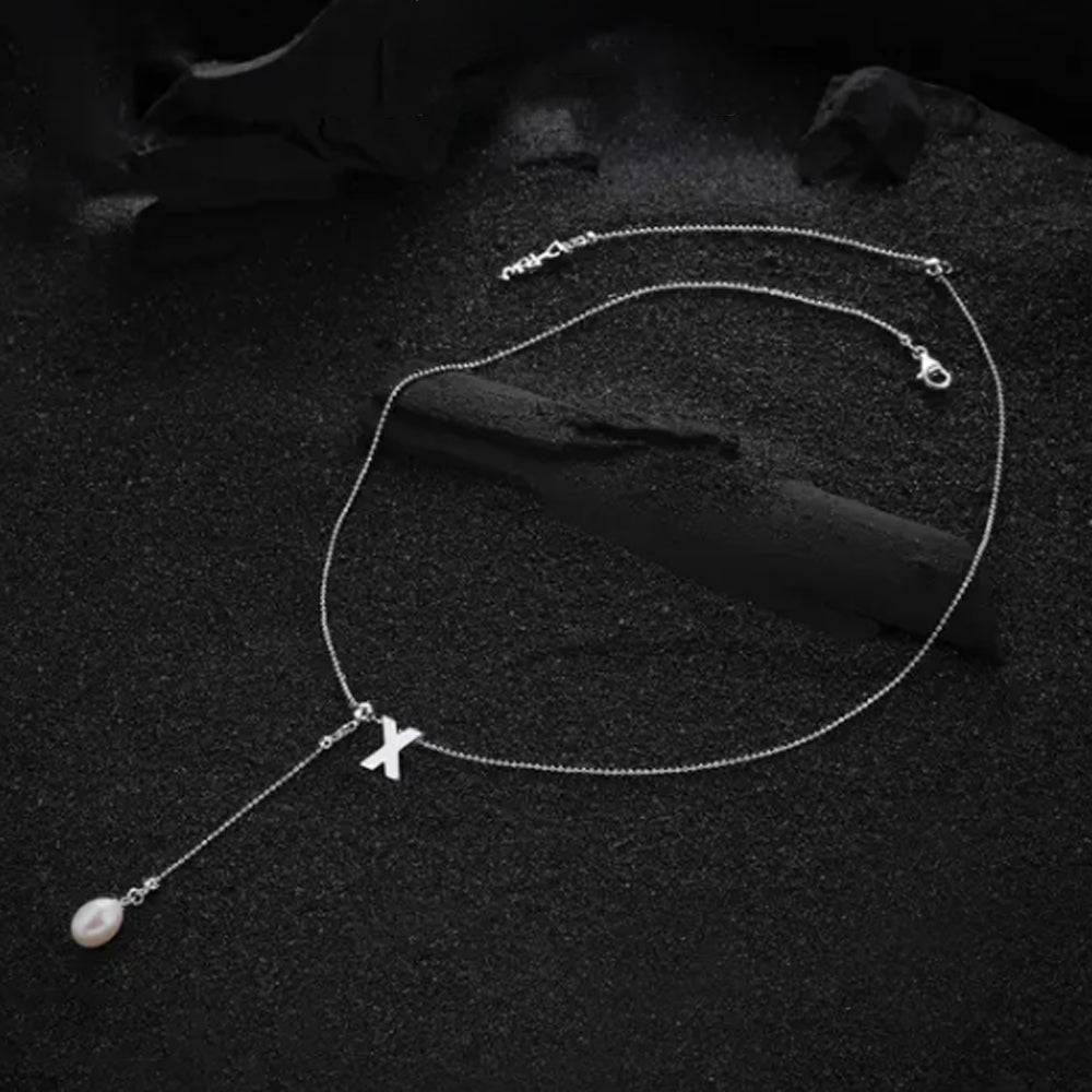 Letter "X" pendant from the cream-colored letter necklace, showcasing its minimalist style and smooth finish.
