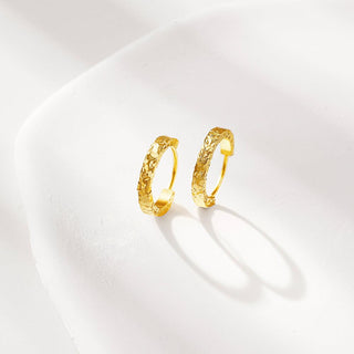 Angled view of the gold crushed ice hoop earrings, showcasing the dimensional shine and irregular surface design.