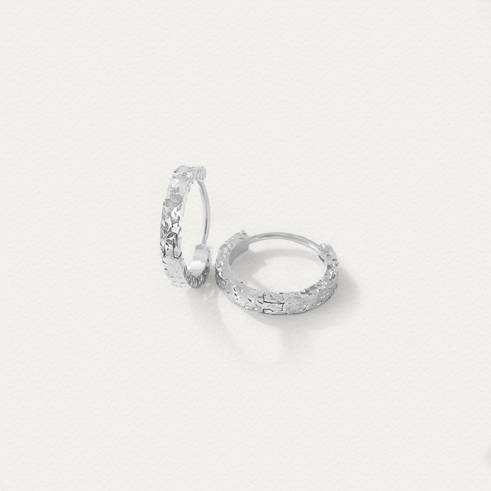 Side angle of the silver crushed ice textured hoop earrings, showing the thickness and radiant hammered detailing.