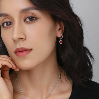 Close-up of earrings worn by model, showing the balance between the silver setting and heart-shaped agate.