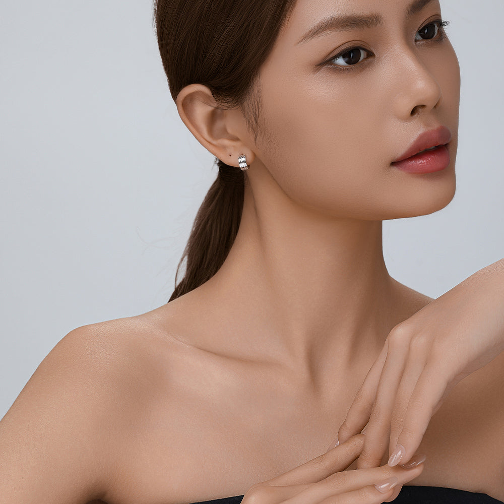Model wearing D-POW hammered sterling silver ear cuffs, showcasing the elegant design and fit on the ear in a lifestyle shot.