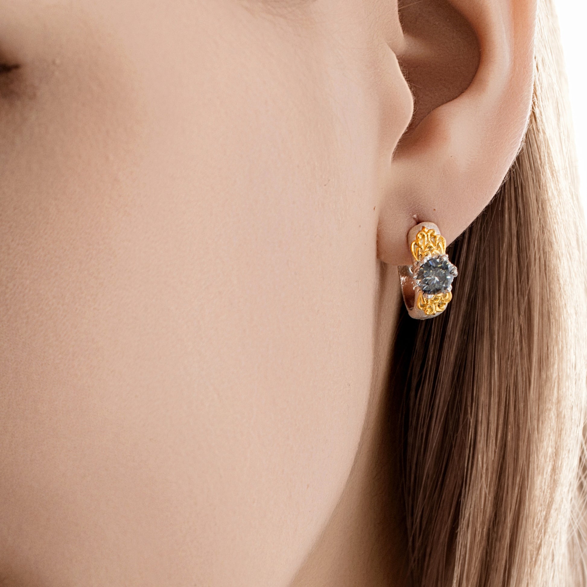 Close-up of the gold Eternal Gleam ear clips on model, showing how they catch light elegantly.