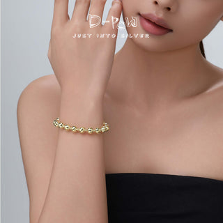 Lifestyle shot of the model wearing the sterling silver bracelet, capturing its cosmic texture in a natural, everyday setting.