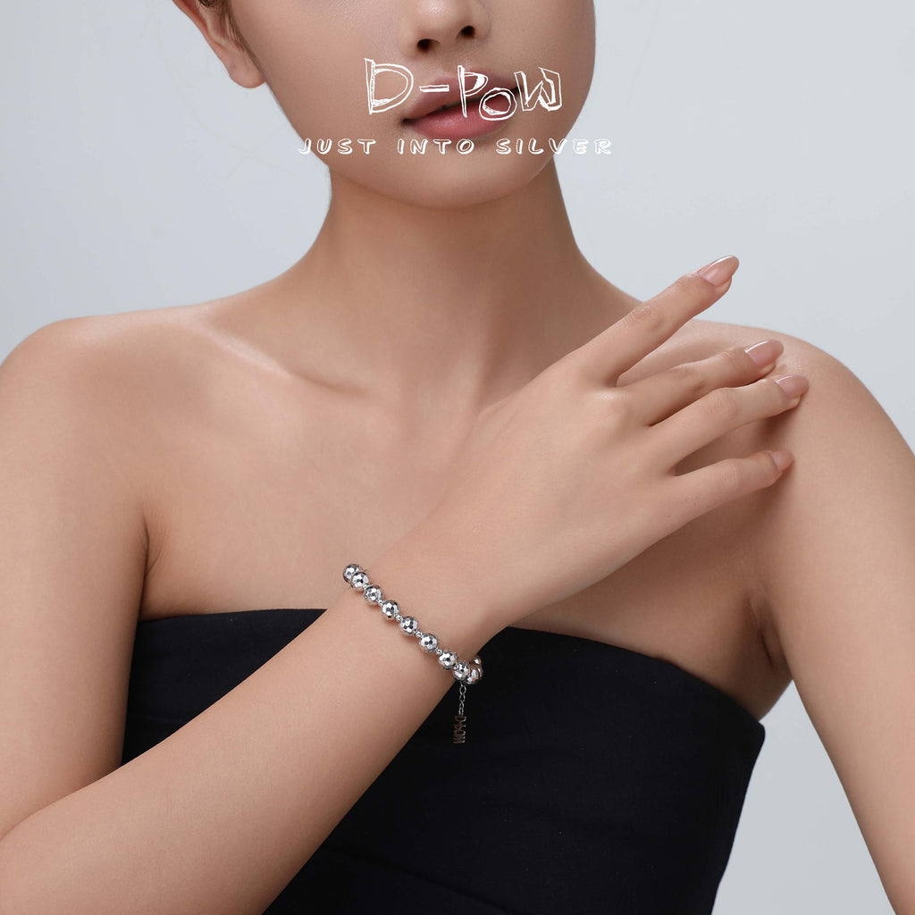 Side view of the bracelet on the model's wrist, highlighting the broken texture and reflective shine of the silver finish.