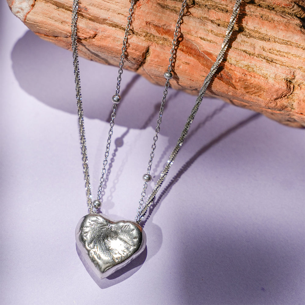 Side angle view of the necklace, emphasizing the graceful curves of the white peach pendant and its subtle shimmer.
