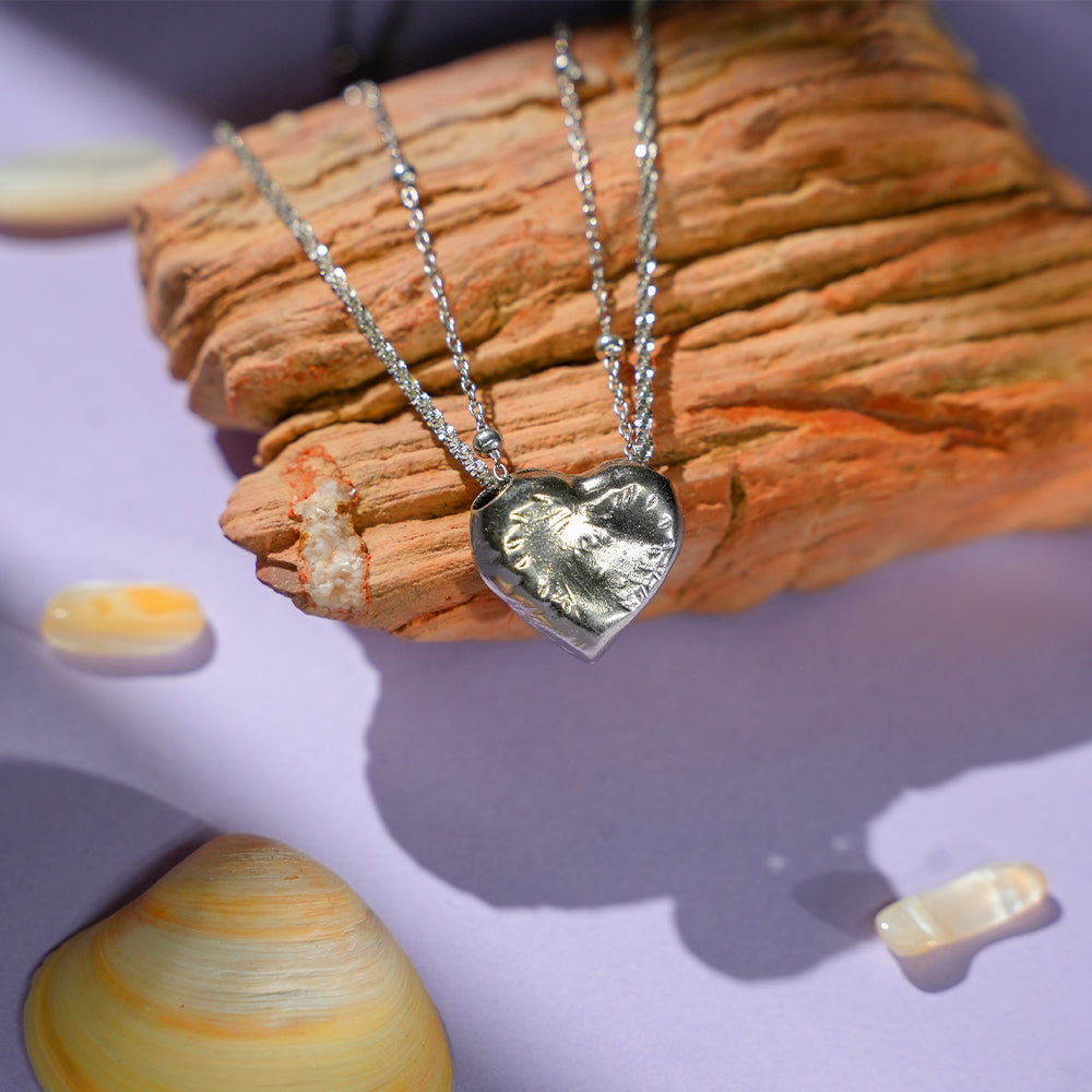 Close-up of the Little White Peach Necklace, highlighting the fine craftsmanship of the pendant and the smooth finish of the silver chain.