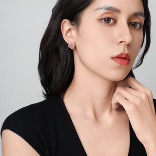 Model wearing Lustre Ruyi earrings, showing the subtle shine of the red stone against the earlobe.