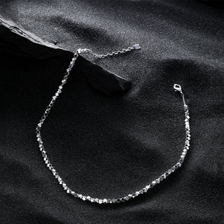 Side angle view of the necklace highlighting the geometric facets of the pendant and the sleek chain, emphasizing its bold, structured design.