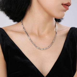 Side view of the model wearing the necklace, highlighting the pendant's sculptural details and the necklace's modern, heavy craft style.