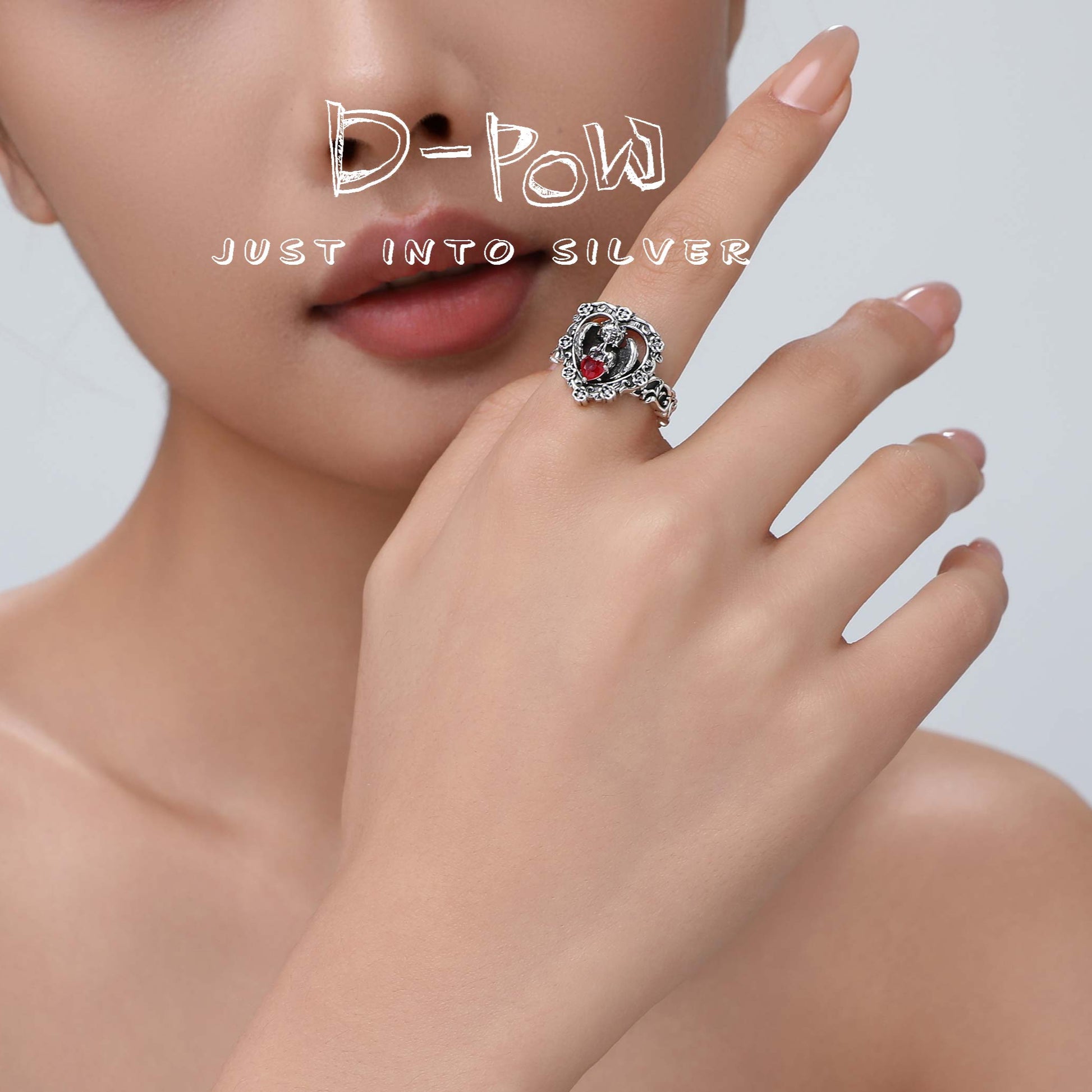 Lifestyle image of the model wearing the red gemstone ring, conveying its romantic and ethereal charm in a natural setting.