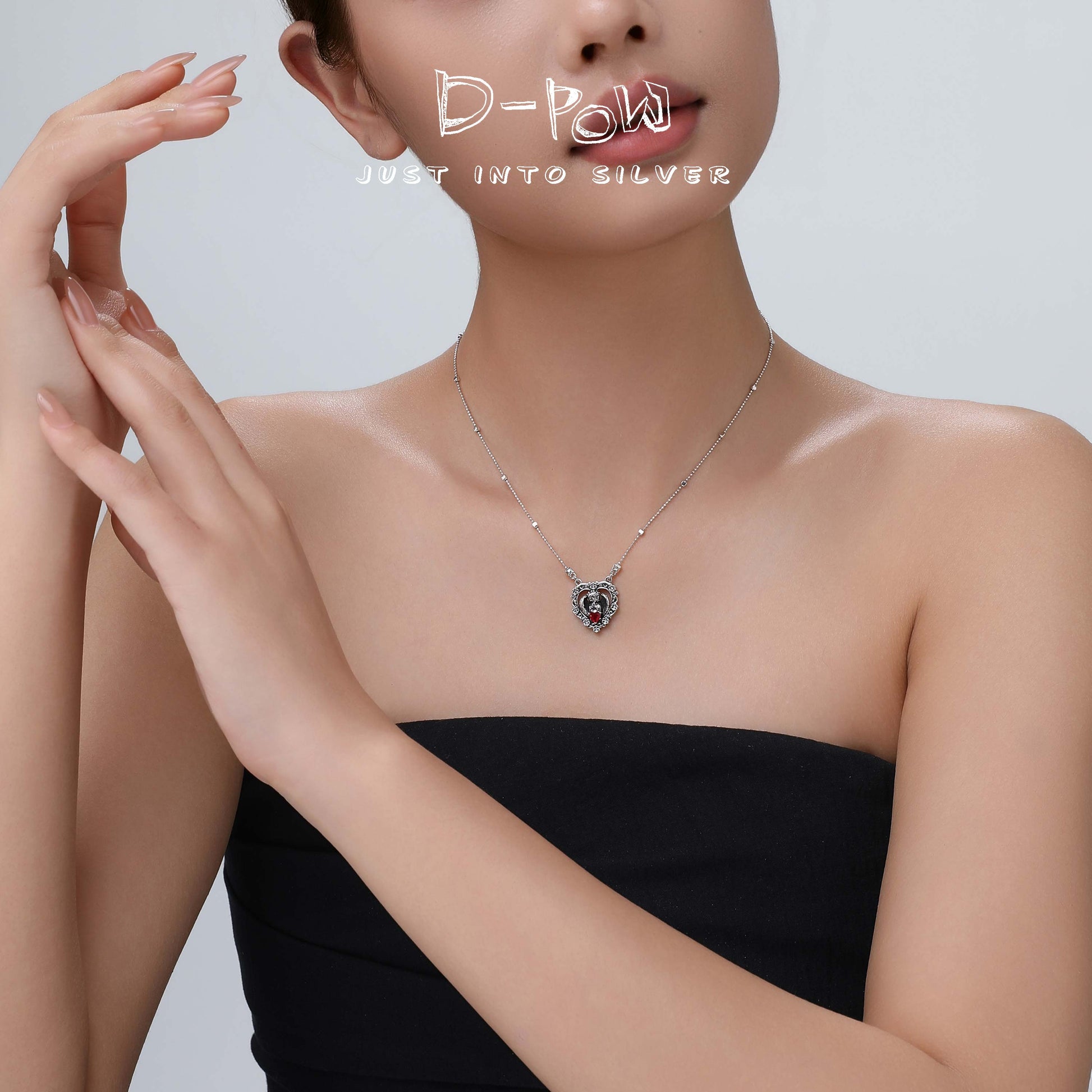 Lifestyle shot of the model showcasing the red gem heart necklace, capturing its romantic elegance against the neckline.