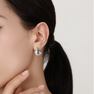 Model wearing the silver Shattered Cosmos ear cuff, showing its snug fit and contemporary shine on the ear.