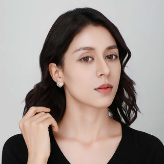 Model wearing one Shatterlight heart stud, demonstrating its subtle sparkle and delicate size on the ear.